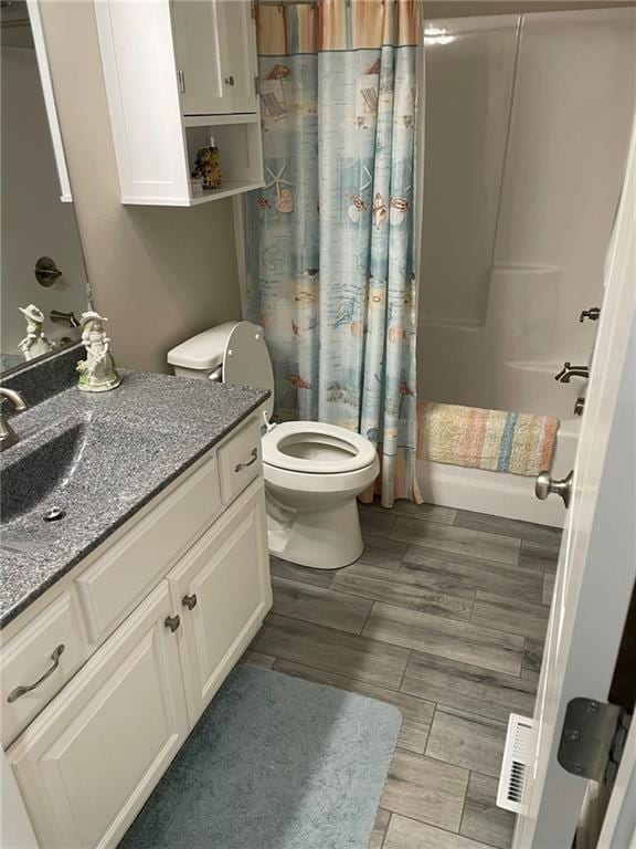 5205 University Ave, Saint Joseph, MO 64503 - full bathroom with vanity, shower / tub combo, and wood finish floors