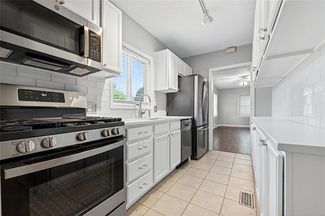 7617 W 63rd Ter, Overland Park, KS 66202 - kitchen featuring stainless steel appliances, light tile patterned floors, white cabinetry, light countertops, and a textured ceiling