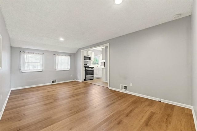 7617 W 63rd Ter, Overland Park, KS 66202 - empty room featuring light wood-type flooring, a textured ceiling, recessed lighting, and a smoke detector