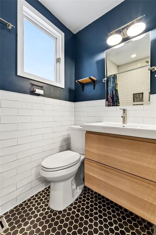 7617 W 63rd Ter, Overland Park, KS 66202 - bathroom with tile walls, vanity, and wainscoting