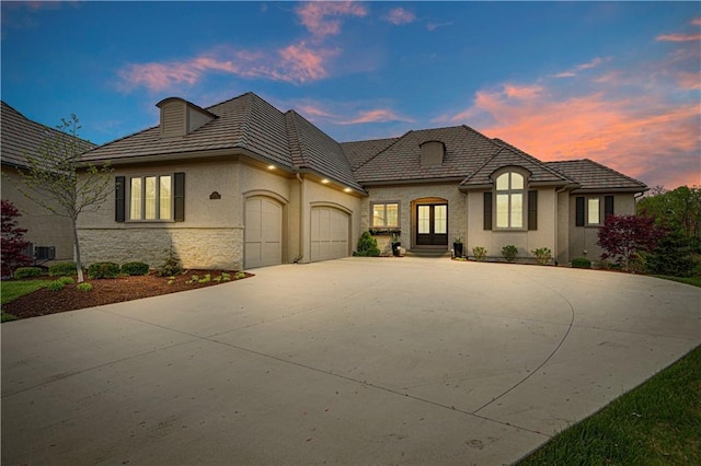 2144 W 89th Ter, Leawood, KS 66206 - view of front facade with an attached garage, concrete driveway, stone siding, and stucco siding