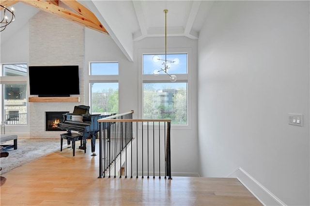2144 W 89th Ter, Leawood, KS 66206 - staircase with a chandelier, wood finished floors, beam ceiling, a large fireplace, and high vaulted ceiling