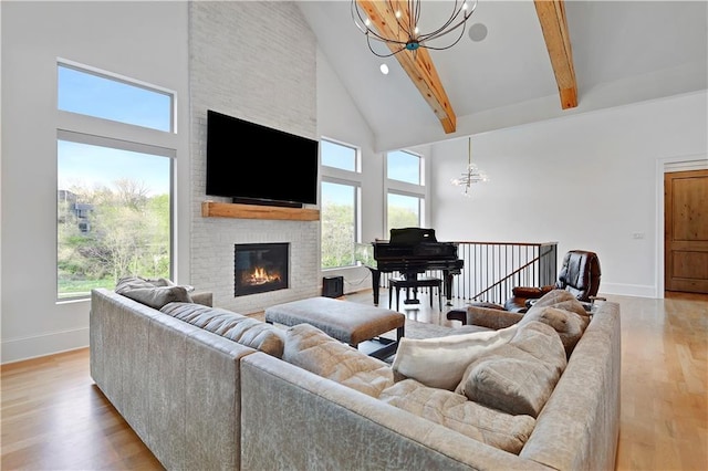 2144 W 89th Ter, Leawood, KS 66206 - living area featuring a chandelier, high vaulted ceiling, light wood-style floors, beam ceiling, and a brick fireplace