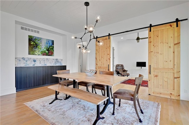 2144 W 89th Ter, Leawood, KS 66206 - dining area featuring a barn door, light wood-style flooring, and a chandelier