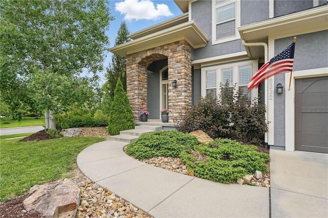 9332 W 158th St, Overland Park, KS 66221 - view of exterior entry with stucco siding, a yard, and stone siding