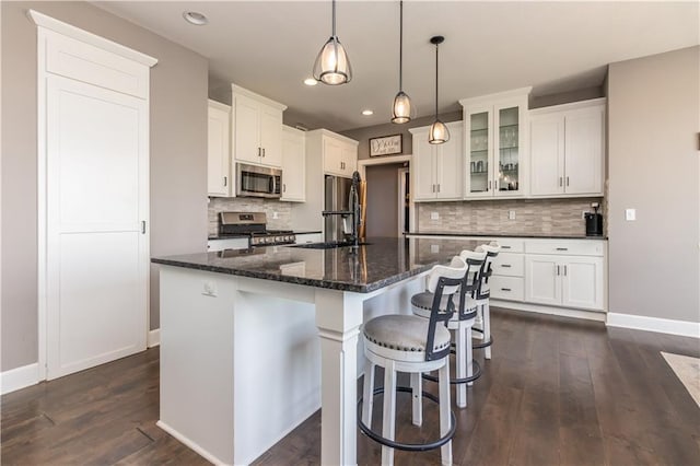 25096 W 87th St, Lenexa, KS 66227 - kitchen featuring appliances with stainless steel finishes, a center island, dark wood-style flooring, tasteful backsplash, and recessed lighting