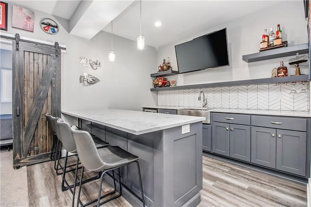 25096 W 87th St, Lenexa, KS 66227 - bar with a barn door, light wood finished floors, backsplash, decorative light fixtures, and recessed lighting