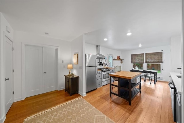 2017 W 48th St, Westwood, KS 66205 - kitchen with stainless steel appliances, wall chimney range hood, light wood-style flooring, and recessed lighting
