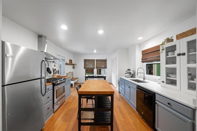 2017 W 48th St, Westwood, KS 66205 - kitchen featuring appliances with stainless steel finishes, ventilation hood, gray cabinets, light wood-type flooring, and recessed lighting