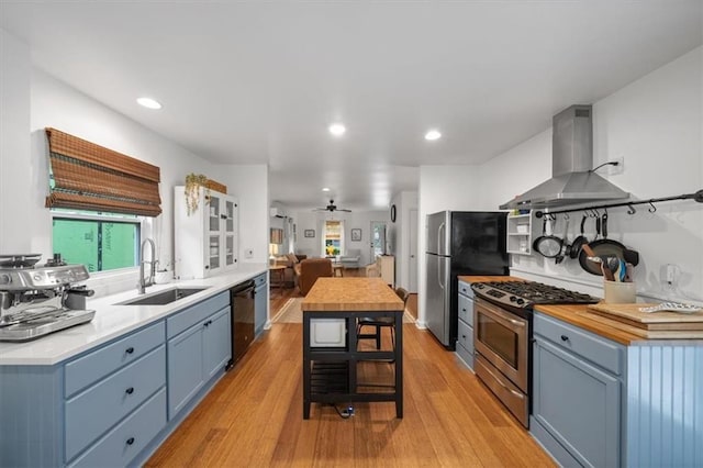 2017 W 48th St, Westwood, KS 66205 - kitchen featuring ventilation hood, appliances with stainless steel finishes, blue cabinets, light wood finished floors, and butcher block counters