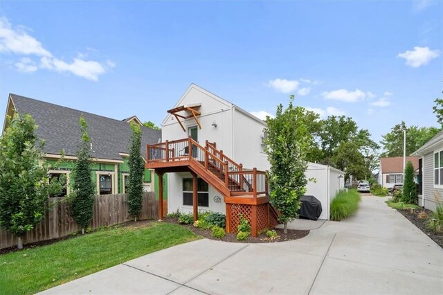 2017 W 48th St, Westwood, KS 66205 - back of property with a wooden deck, stairs, and driveway