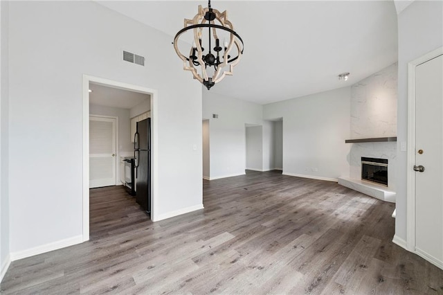 11224 Nieman Rd Unit 302, Overland Park, KS 66210 - unfurnished living room with a chandelier, wood finished floors, and a high end fireplace