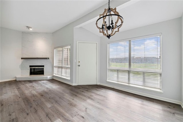 11224 Nieman Rd Unit 302, Overland Park, KS 66210 - unfurnished living room featuring vaulted ceiling, a chandelier, wood finished floors, and a fireplace