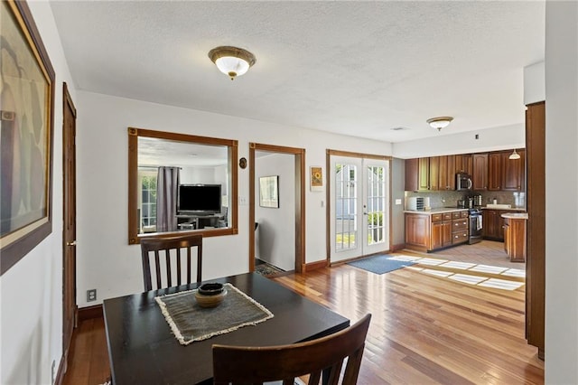 1015 S Wyckford Rd, Olathe, KS 66061 - dining room featuring light wood-style flooring and a textured ceiling