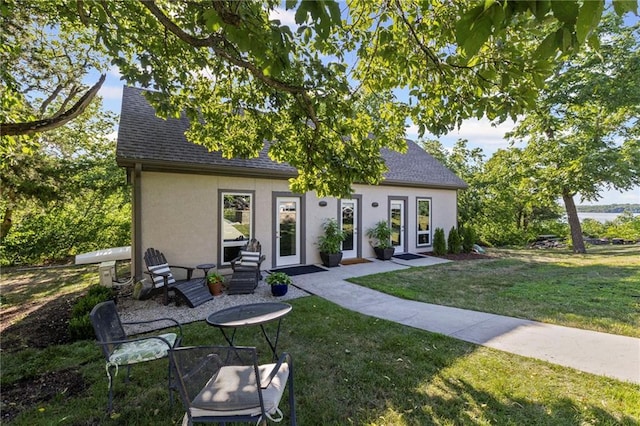 1015 S Wyckford Rd, Olathe, KS 66061 - view of front of house with stucco siding, roof with shingles, and a front yard