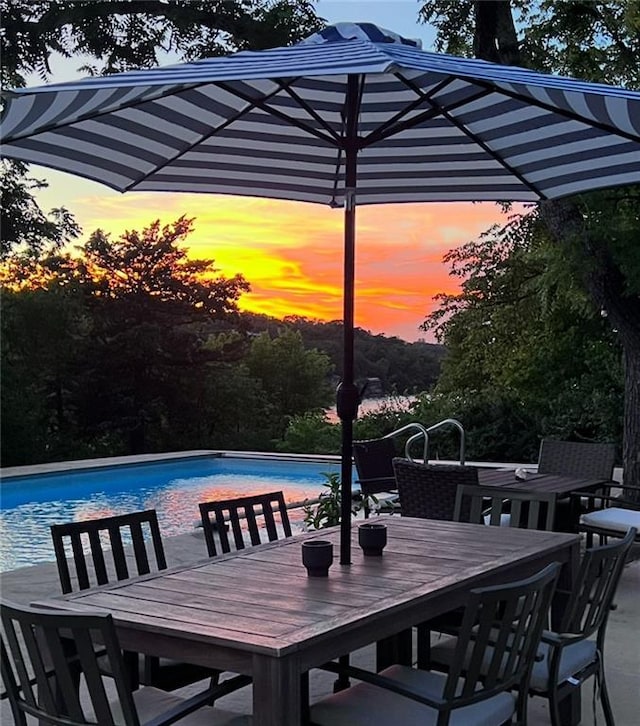 1015 S Wyckford Rd, Olathe, KS 66061 - patio terrace at dusk featuring an outdoor pool and outdoor dining space