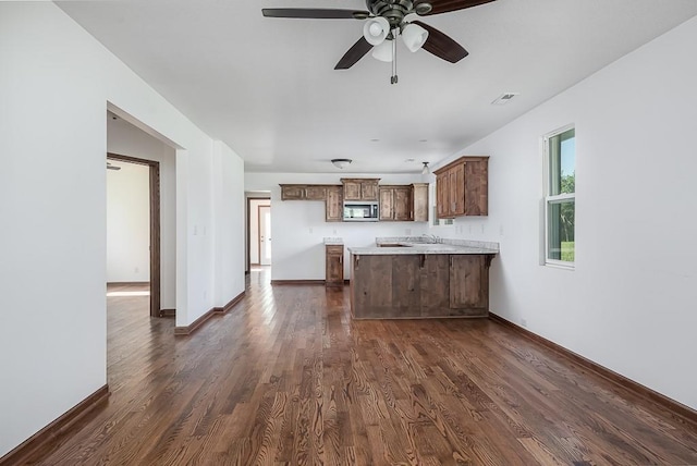 17931 Hollingsworth Rd, Tonganoxie, KS 66086 - kitchen featuring stainless steel microwave, a peninsula, light countertops, dark wood-type flooring, and ceiling fan