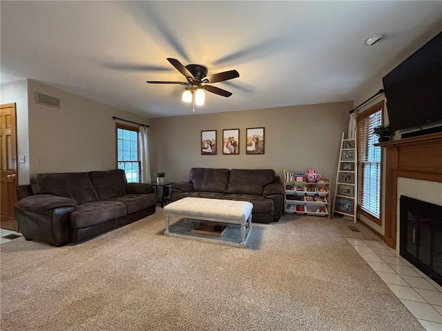 2006 Buckingham St, Saint Joseph, MO 64506 - living area with a ceiling fan, light colored carpet, a tiled fireplace, and light tile patterned floors