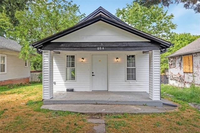 804 S Cedar Ave, Independence, MO 64053 - shotgun-style home featuring a porch and a front lawn