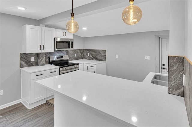 804 S Cedar Ave, Independence, MO 64053 - kitchen with stainless steel appliances, wood finished floors, backsplash, and white cabinets