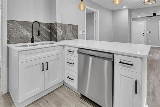 804 S Cedar Ave, Independence, MO 64053 - kitchen featuring dishwasher, a peninsula, white cabinets, light countertops, and hanging light fixtures
