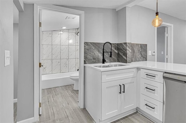 804 S Cedar Ave, Independence, MO 64053 - kitchen featuring stainless steel dishwasher, white cabinets, light countertops, decorative light fixtures, and light wood-type flooring