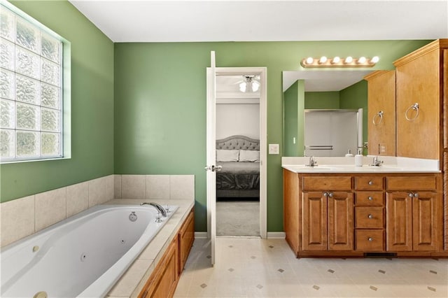 2105 NW Sweetgum Ct, Grain Valley, MO 64029 - full bath featuring ensuite bath, double vanity, a jetted tub, a ceiling fan, and tile patterned floors