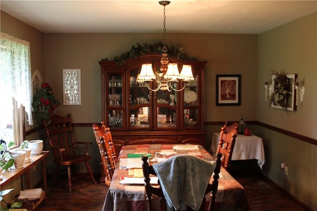 612 N 4th St, Arma, KS 66712 - dining space featuring a chandelier, plenty of natural light, and wood finished floors