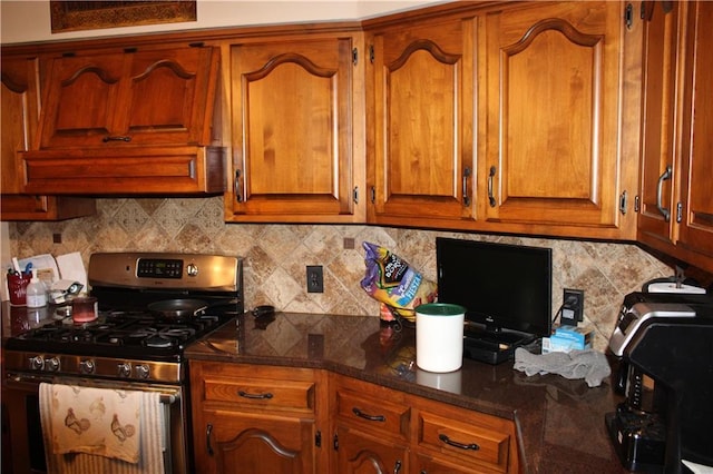 612 N 4th St, Arma, KS 66712 - kitchen with gas range, brown cabinets, decorative backsplash, and dark stone counters