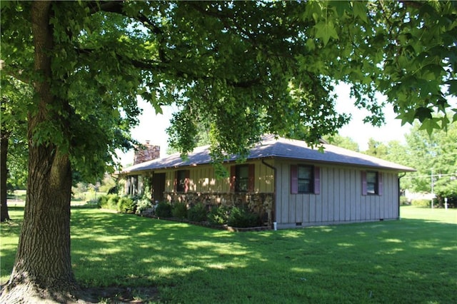 612 N 4th St, Arma, KS 66712 - view of property exterior with board and batten siding, a yard, a chimney, and crawl space