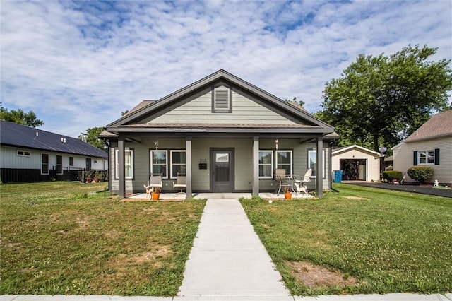311 S 3rd St, Odessa, MO 64076 - view of front of house with a front yard, an outbuilding, covered porch, and a detached garage