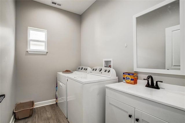 311 S 3rd St, Odessa, MO 64076 - washroom featuring independent washer and dryer, wood finished floors, and cabinet space