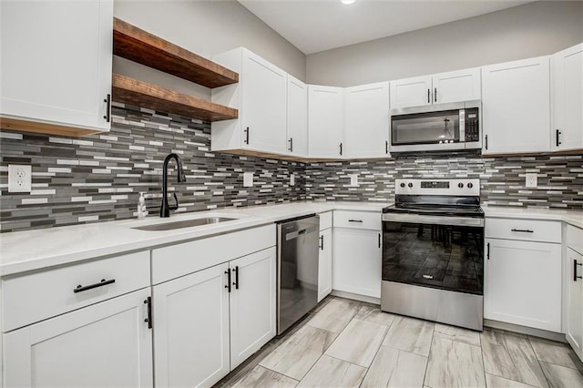 311 S 3rd St, Odessa, MO 64076 - kitchen featuring stainless steel appliances, open shelves, light countertops, and white cabinets
