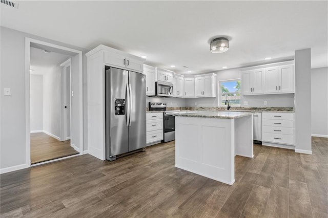 812 W Royle St, Richmond, MO 64085 - kitchen featuring appliances with stainless steel finishes, white cabinetry, dark wood-style flooring, a center island, and recessed lighting