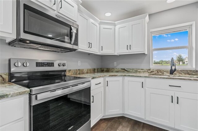 812 W Royle St, Richmond, MO 64085 - kitchen featuring stainless steel appliances, white cabinetry, dark wood finished floors, light stone counters, and recessed lighting