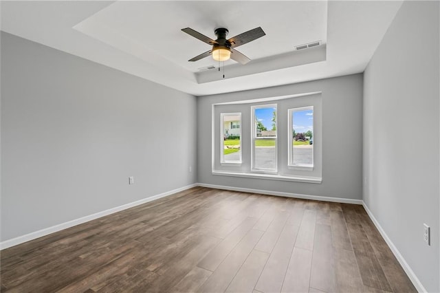 812 W Royle St, Richmond, MO 64085 - spare room featuring a tray ceiling, wood finished floors, and ceiling fan
