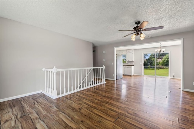 1138 S Willow St, Ottawa, KS 66067 - empty room with a textured ceiling, wood finished floors, a ceiling fan, and a chandelier