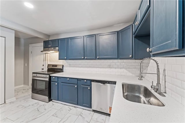 4320 E 43rd St, Kansas City, MO 64130 - kitchen featuring appliances with stainless steel finishes, under cabinet range hood, blue cabinets, light countertops, and light marble finish flooring