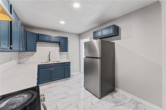 4320 E 43rd St, Kansas City, MO 64130 - kitchen with freestanding refrigerator, light countertops, tasteful backsplash, blue cabinets, and recessed lighting