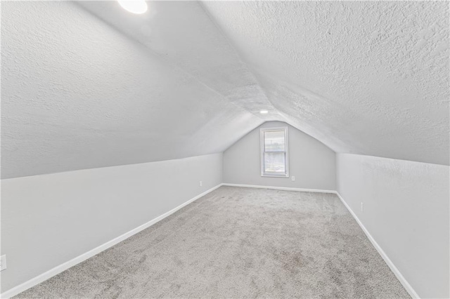 4320 E 43rd St, Kansas City, MO 64130 - additional living space with a textured ceiling, vaulted ceiling, and carpet flooring