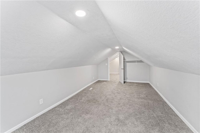 4320 E 43rd St, Kansas City, MO 64130 - bonus room featuring a textured ceiling, lofted ceiling, and carpet flooring