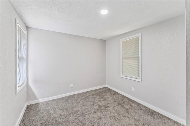 4320 E 43rd St, Kansas City, MO 64130 - spare room featuring carpet, a textured ceiling, and healthy amount of natural light