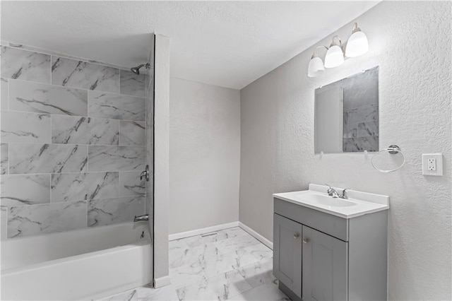 4320 E 43rd St, Kansas City, MO 64130 - bathroom with vanity, washtub / shower combination, marble look tile flooring, a textured wall, and a textured ceiling