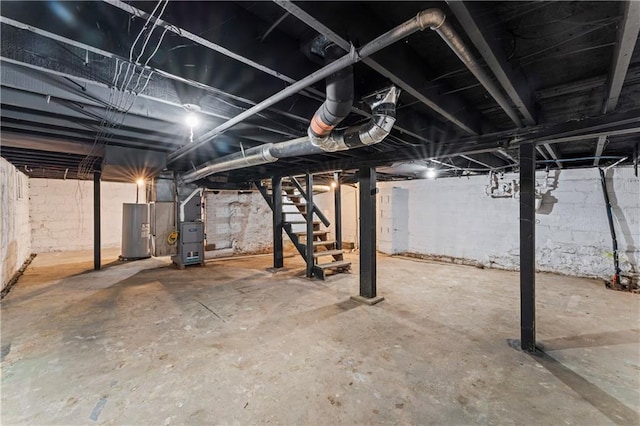 4320 E 43rd St, Kansas City, MO 64130 - unfinished basement with stairs, electric water heater, and heating unit