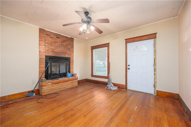 919 Indiana St, Neodesha, KS 66757 - unfurnished living room featuring hardwood / wood-style flooring, ceiling fan, ornamental molding, and a fireplace