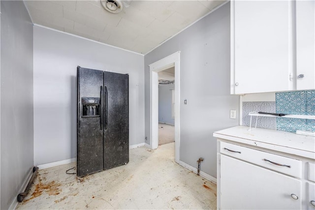 919 Indiana St, Neodesha, KS 66757 - kitchen featuring black fridge, light countertops, white cabinets, and crown molding