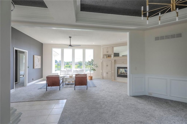129 SE Chelsea Dr, Lees Summit, MO 64063 - dining room featuring light carpet, ceiling fan, a fireplace with flush hearth, and a raised ceiling