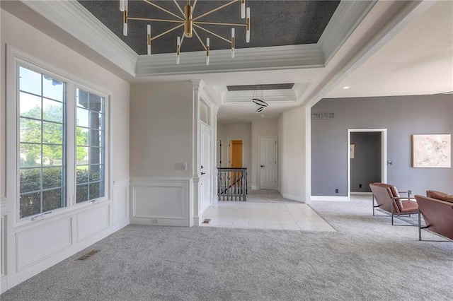 129 SE Chelsea Dr, Lees Summit, MO 64063 - carpeted foyer with crown molding, a raised ceiling, a chandelier, a wainscoted wall, and tile patterned floors