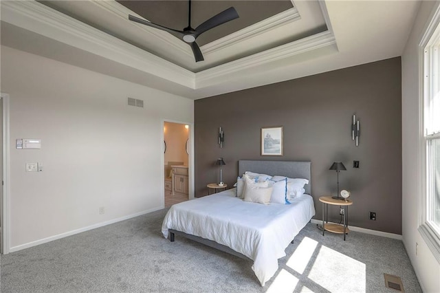129 SE Chelsea Dr, Lees Summit, MO 64063 - carpeted bedroom featuring a raised ceiling, crown molding, multiple windows, ensuite bath, and a ceiling fan