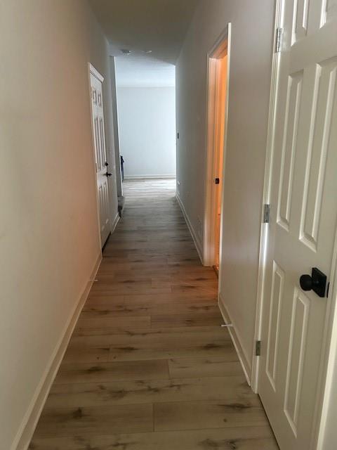 211 Harrison St, Pomona, KS 66076 - corridor featuring light wood-type flooring and baseboards
